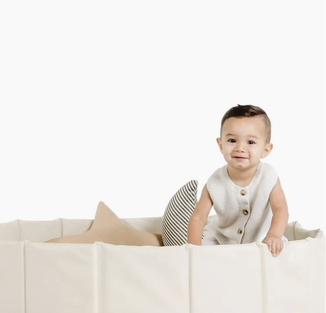 A soft-sided vegan leather ball pit in a family living room, product photo.