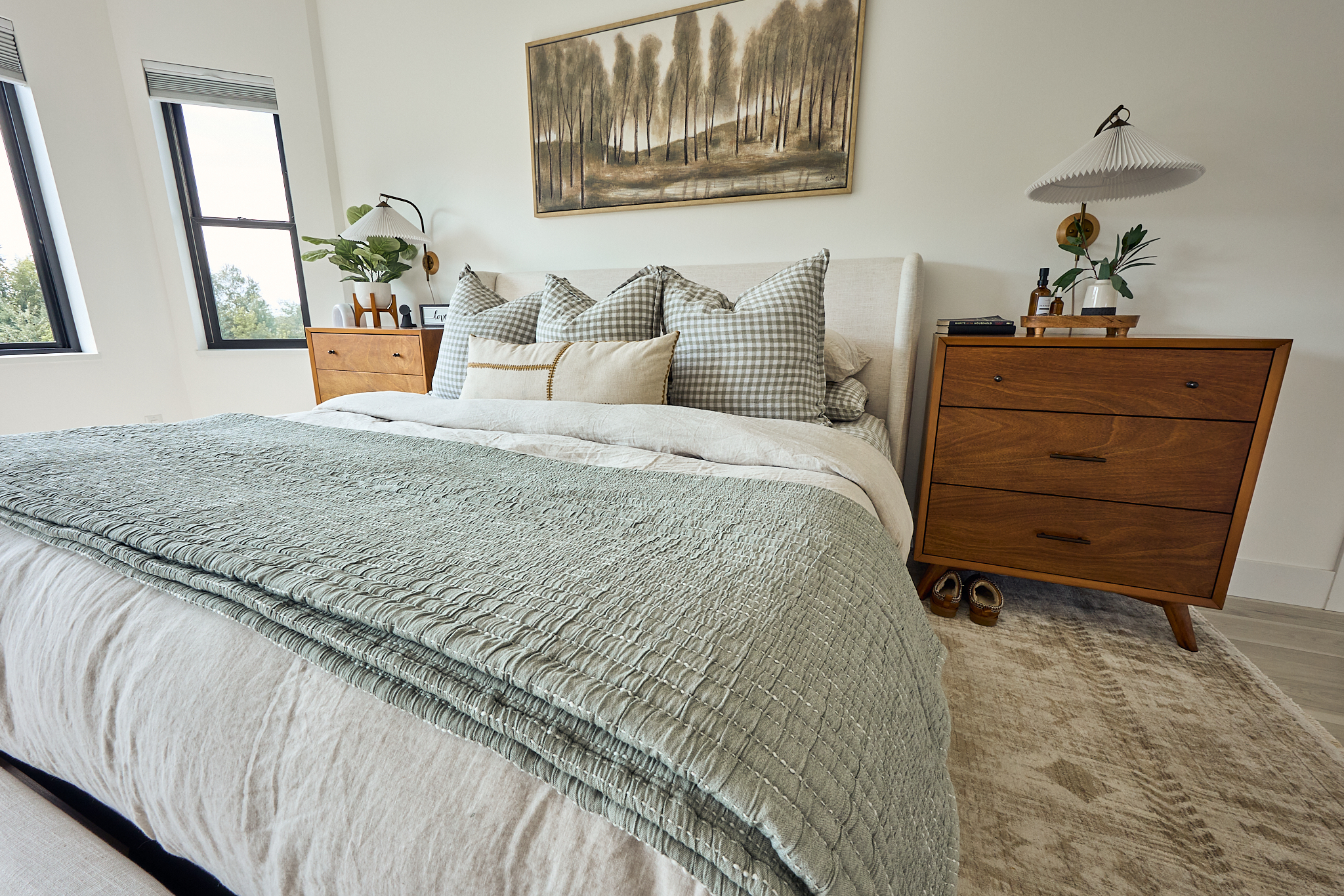 Dresser, wall sconce, and fringed area rug in the refreshed bedroom