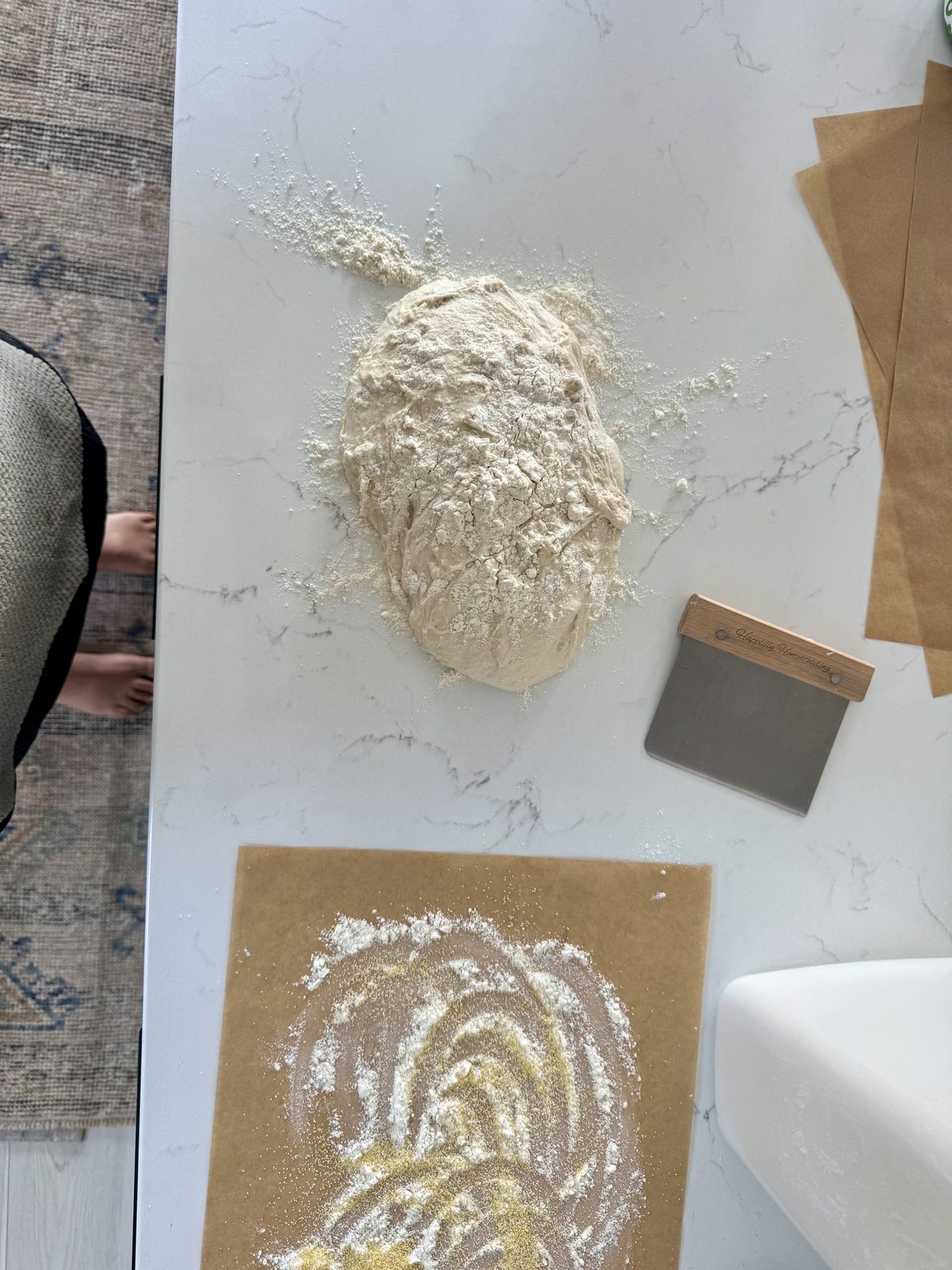 Shaped sourdough pizza dough ball with a bench scraper